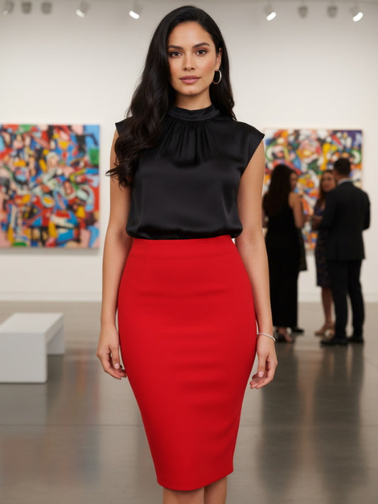 Woman in black top and red skirt standing in an art gallery.