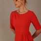 Model wearing the Diva Lynette dress in pencil dress design in fiesta orange front image close up
