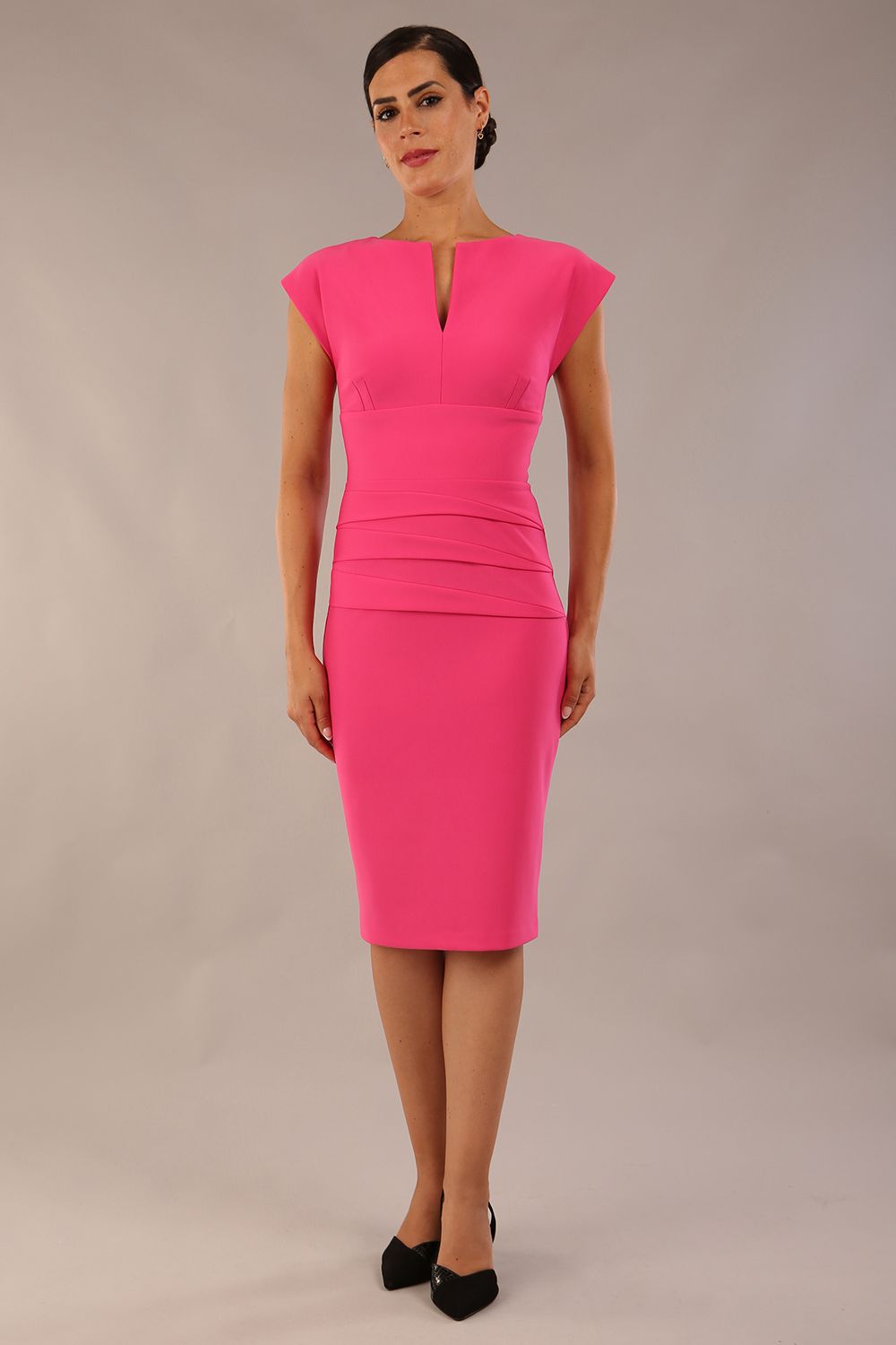 model wearing diva catwalk daphne sleeveless hibiscus pink pencil dress with rounded neckline with split in the middle in front