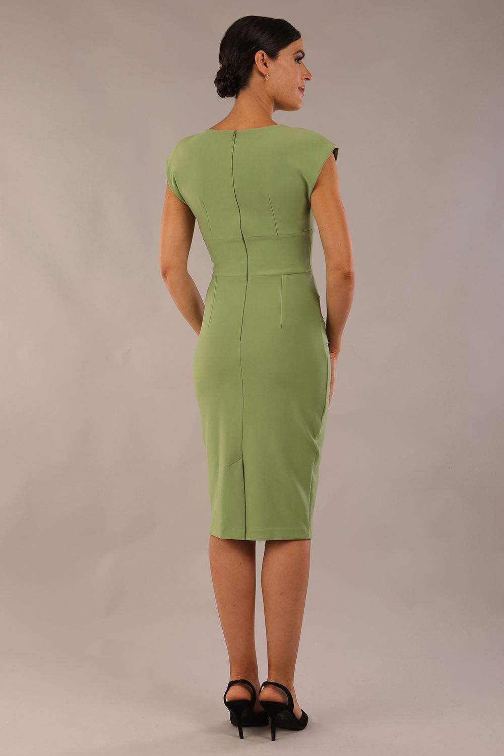 model wearing diva catwalk daphne sleeveless aspen green pencil dress with rounded neckline with split in the middle 