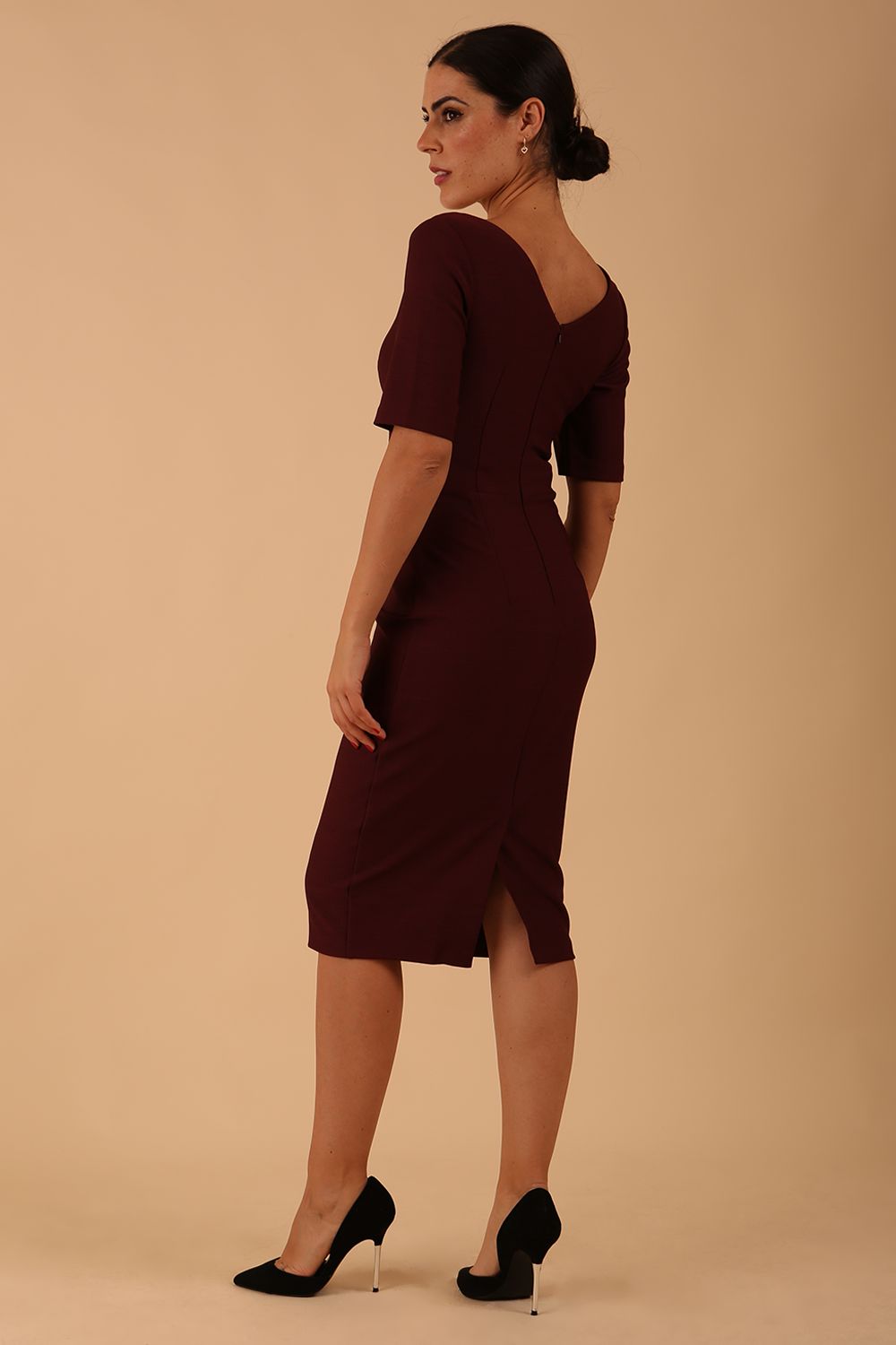 model wearing diva catwalk couture wiltshire fitted pencil-skirt dress with short sleeves and open v-neckline and pleating across the tummy area in port royale colour front