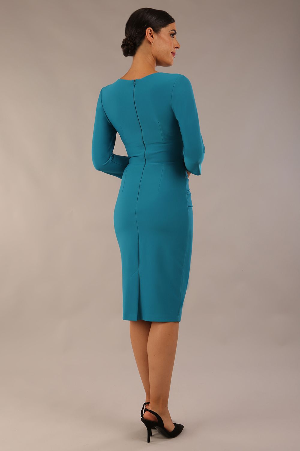 Model wearing the Diva Daphne ¾ Sleeved dress with pleat detail across the hips and ¾ sleeve length in mosaic blue back