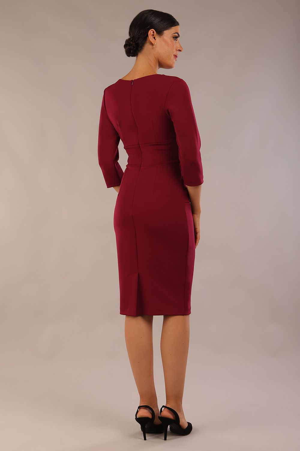 Model wearing the Diva Daphne ¾ Sleeved dress with pleat detail across the hips and ¾ sleeve length in blissful burgundy back