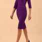 Model wearing the Diva Daphne ¾ Sleeved dress with pleat detail across the hips and ¾ sleeve length in  purple front