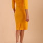 Model wearing the Diva Daphne ¾ Sleeved dress with pleat detail across the hips and ¾ sleeve length in saffron yellow back