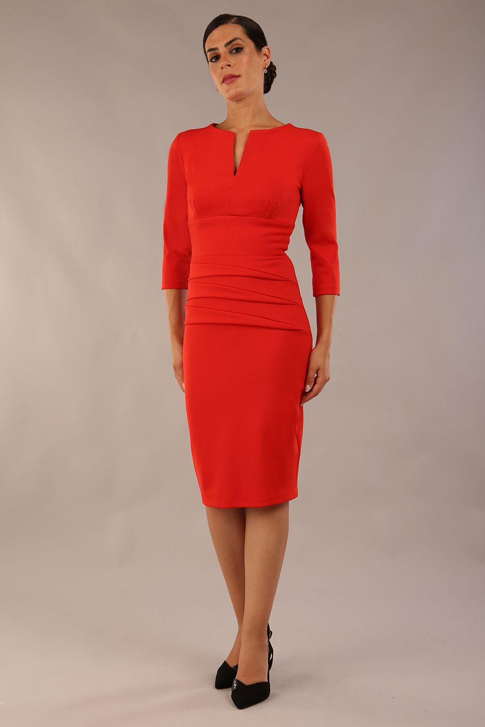 Model wearing Diva catwalk Daphne ¾ Sleeved pencil-skirt dress with pleat detail across the hips and ¾ sleeve length in burnt orange front