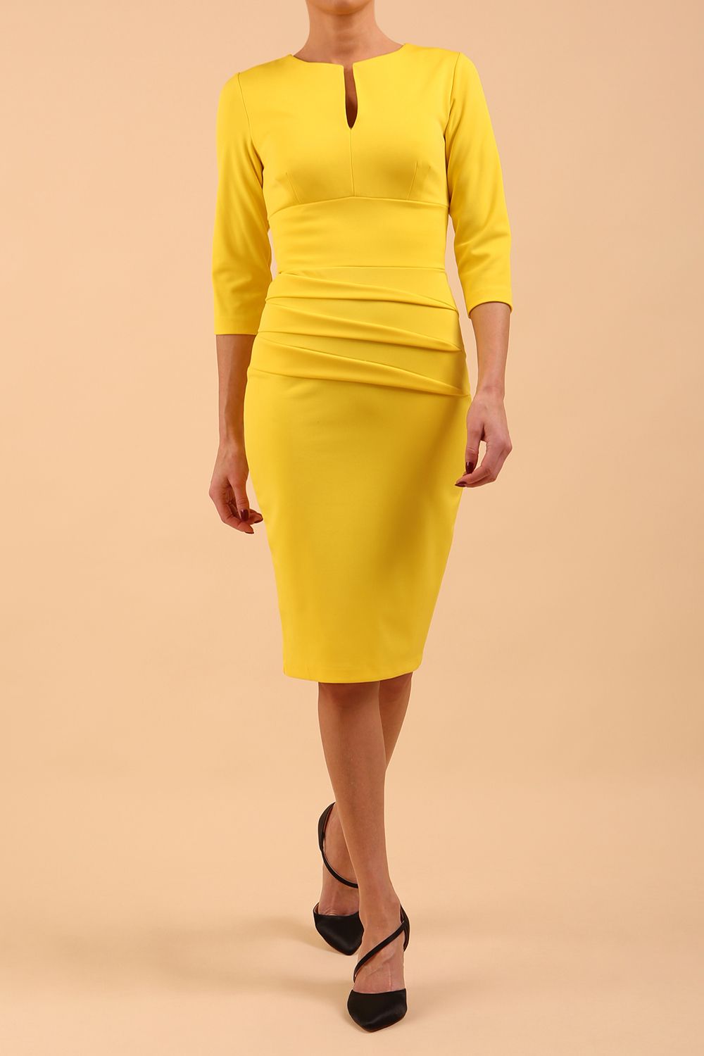 Model wearing Diva catwalk Daphne ¾ Sleeved pencil-skirt dress with pleat detail across the hips and ¾ sleeve length in blazing yellow front