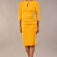 Model wearing the Diva Daphne ¾ Sleeved dress with pleat detail across the hips and ¾ sleeve length in saffron yellow front