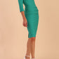 Model wearing the Diva Daphne 3/4 Sleeved dress with pleat detail across the hips and 3/4 sleeve length in Emerald Green side