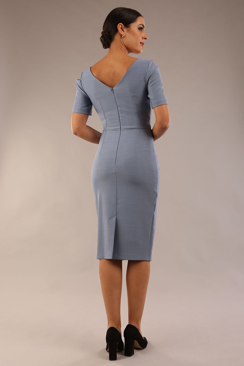 model is wearing diva catwalk seed charlotte pencil plain dress with short sleeve and pleated detail on shoulder in steel blue back