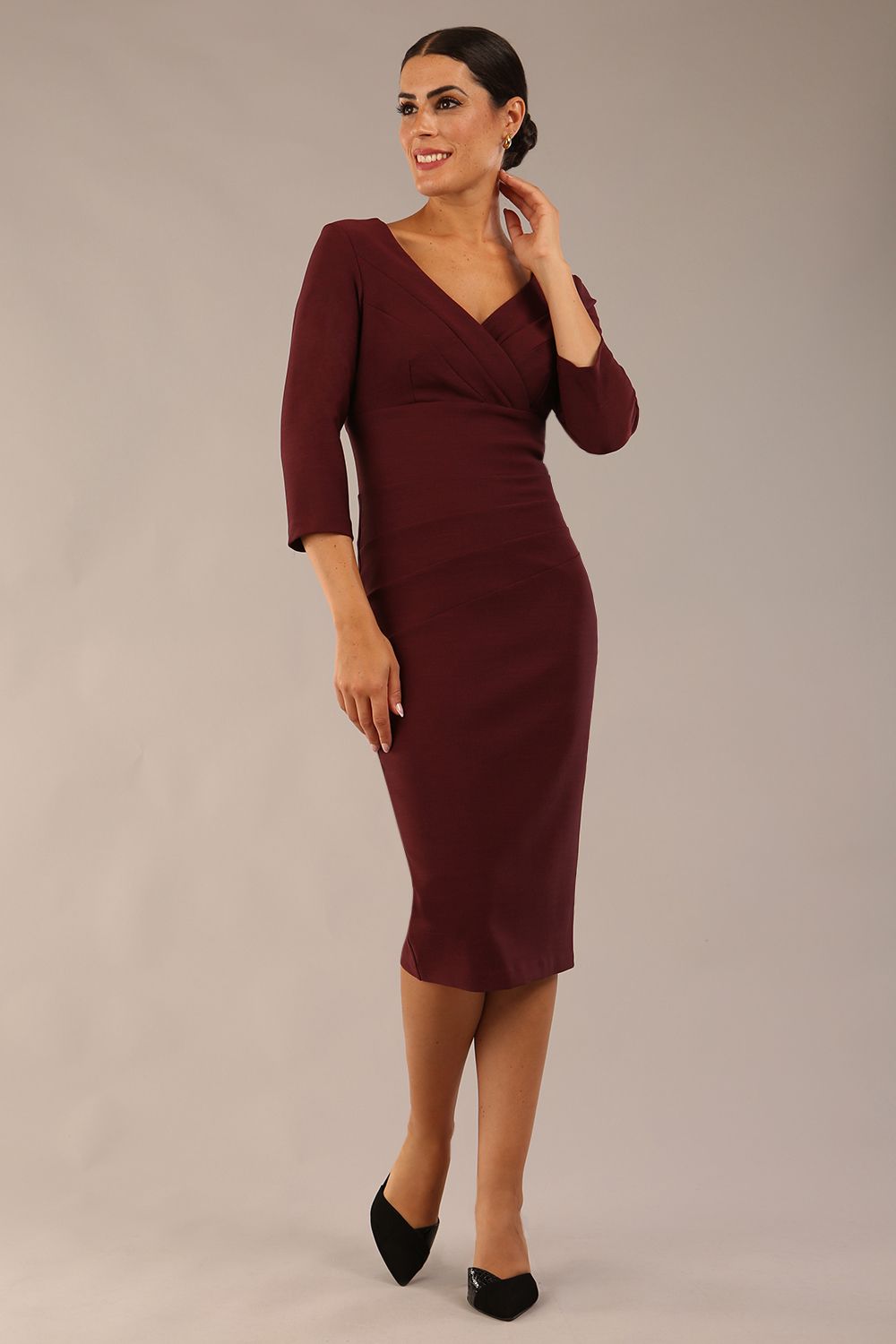 model wearing a diva catwalk Seed Barton Sleeved Pencil Dress 3/4 sleeves and v neckline and knee length with pleating details in port royale colour