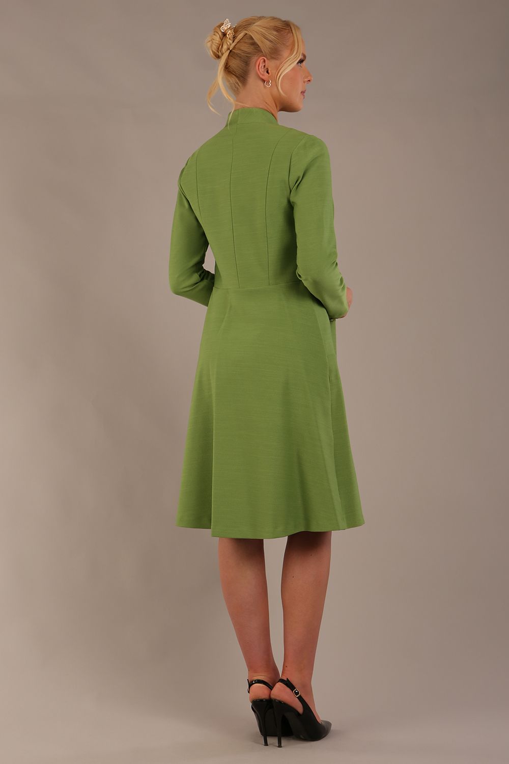 blonde model wearing diva catwalk couture fine raquella coat with buttons across the front and long sleeves with high neck and pockets in citrus green colour back (Citrus Green)