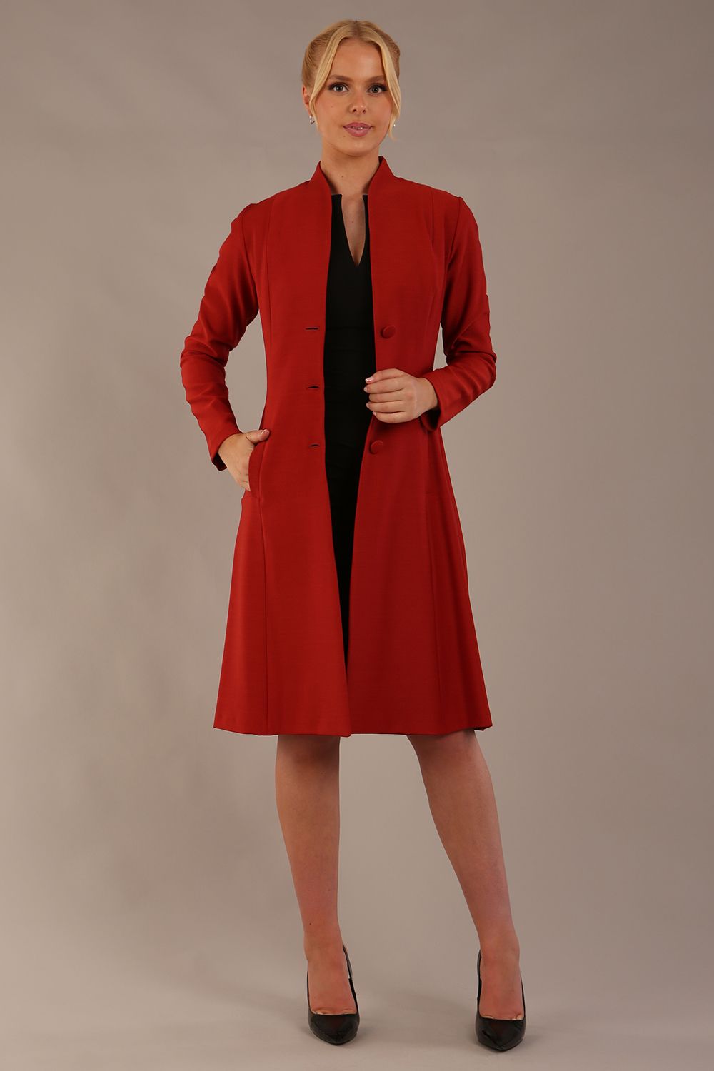 blonde model wearing diva catwalk couture fine raquella coat with buttons across the front and long sleeves with high neck and pockets in garnet red colour front (Garnet Red)