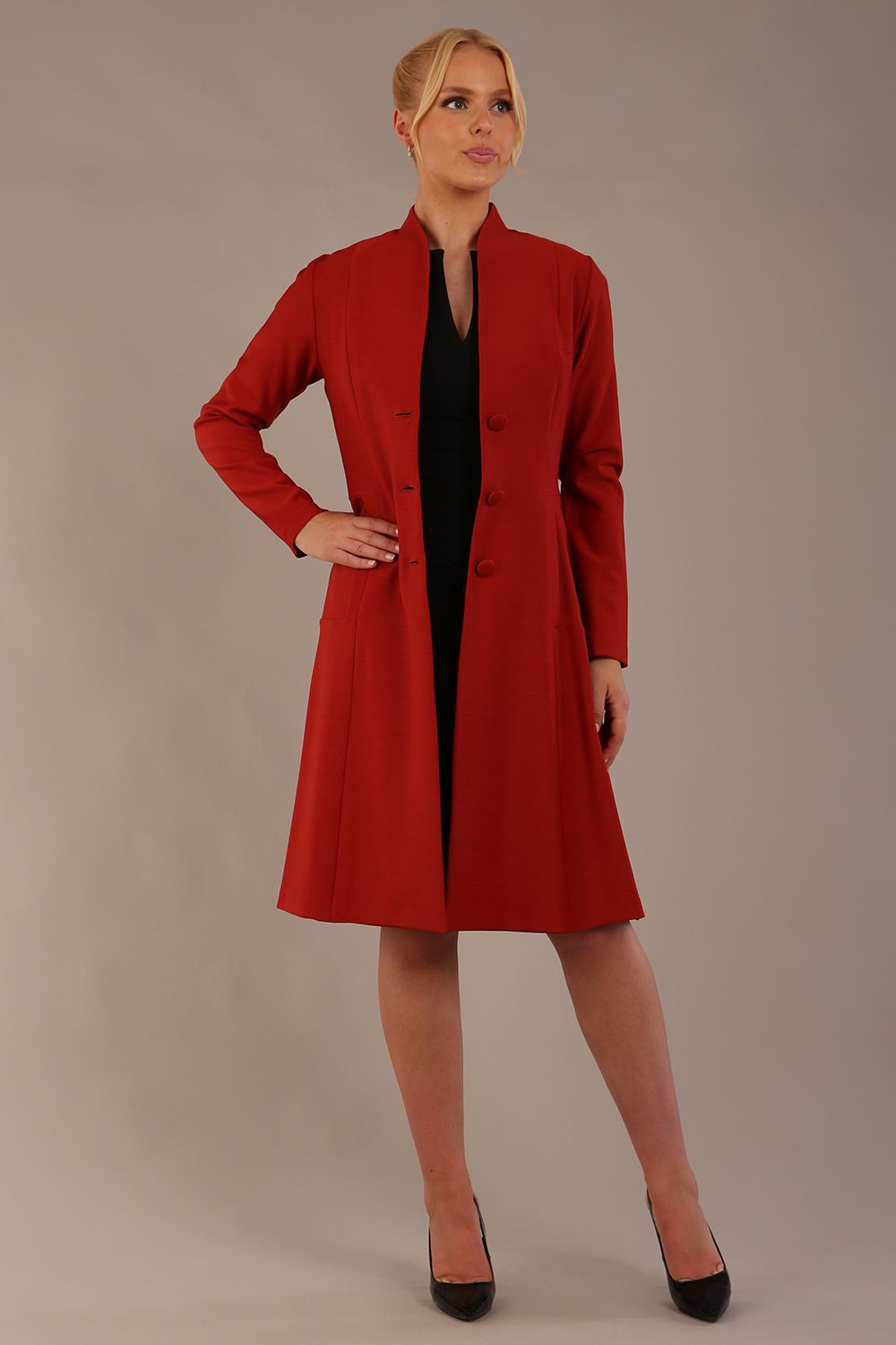 blonde model wearing diva catwalk couture fine raquella coat with buttons across the front and long sleeves with high neck and pockets in garnet red colour front (Garnet Red)