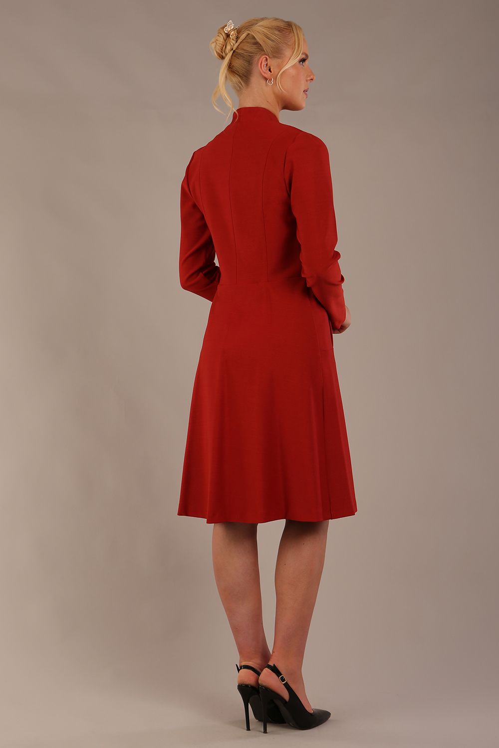 blonde model wearing diva catwalk couture fine raquella coat with buttons across the front and long sleeves with high neck and pockets in garnet red colour back (Garnet Red)