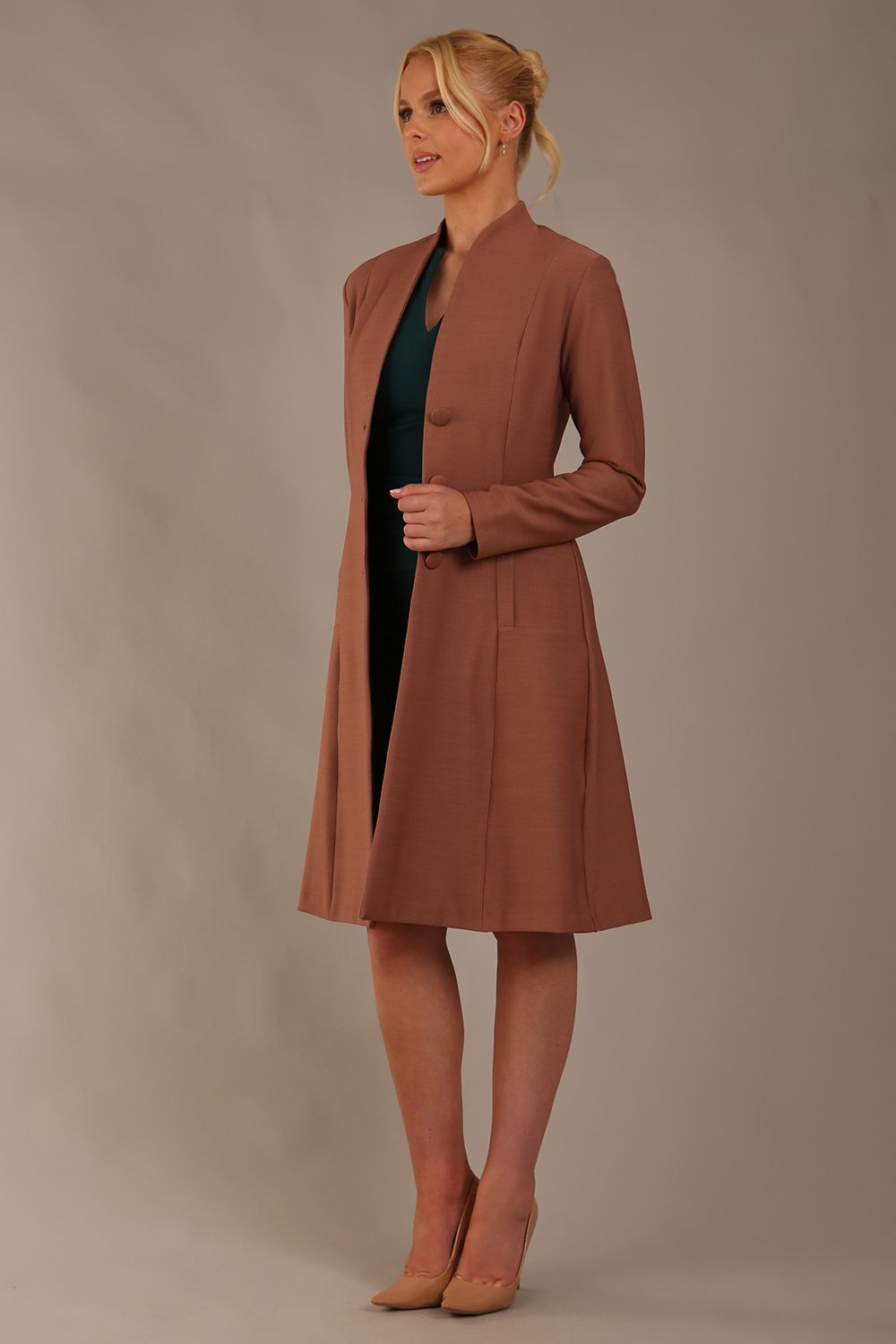 model wearing diva catwalk couture fine raquella coat with buttons across the front and long sleeves with high neck and pockets in acorn brown colour side (Acorn Brown)