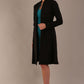 model wearing diva catwalk couture fine raquella coat with buttons across the front and long sleeves with high neck and pockets in black colour front (Black)