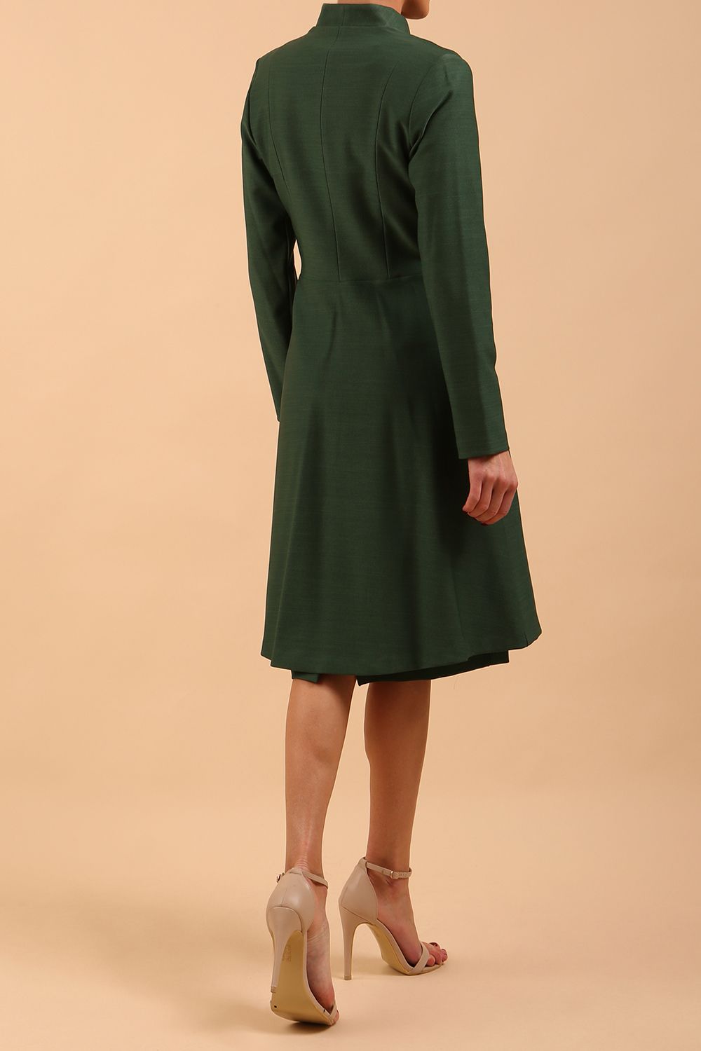 brunette model wearing diva catwalk couture fine raquella coat with buttons across the front and long sleeves with high neck and pockets in chrome green colour back