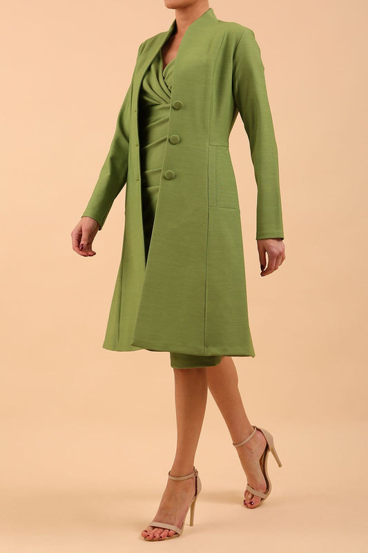 model wearing diva catwalk couture fine raquella coat with buttons across the front and long sleeves with high neck and pockets in citrus green colour front side