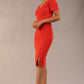 brunette model wearing diva catwalk amorette pencil skirt dress with a cold shoulder detaul and pleating across the bust and slit on a side of skirt in fiesta orange front