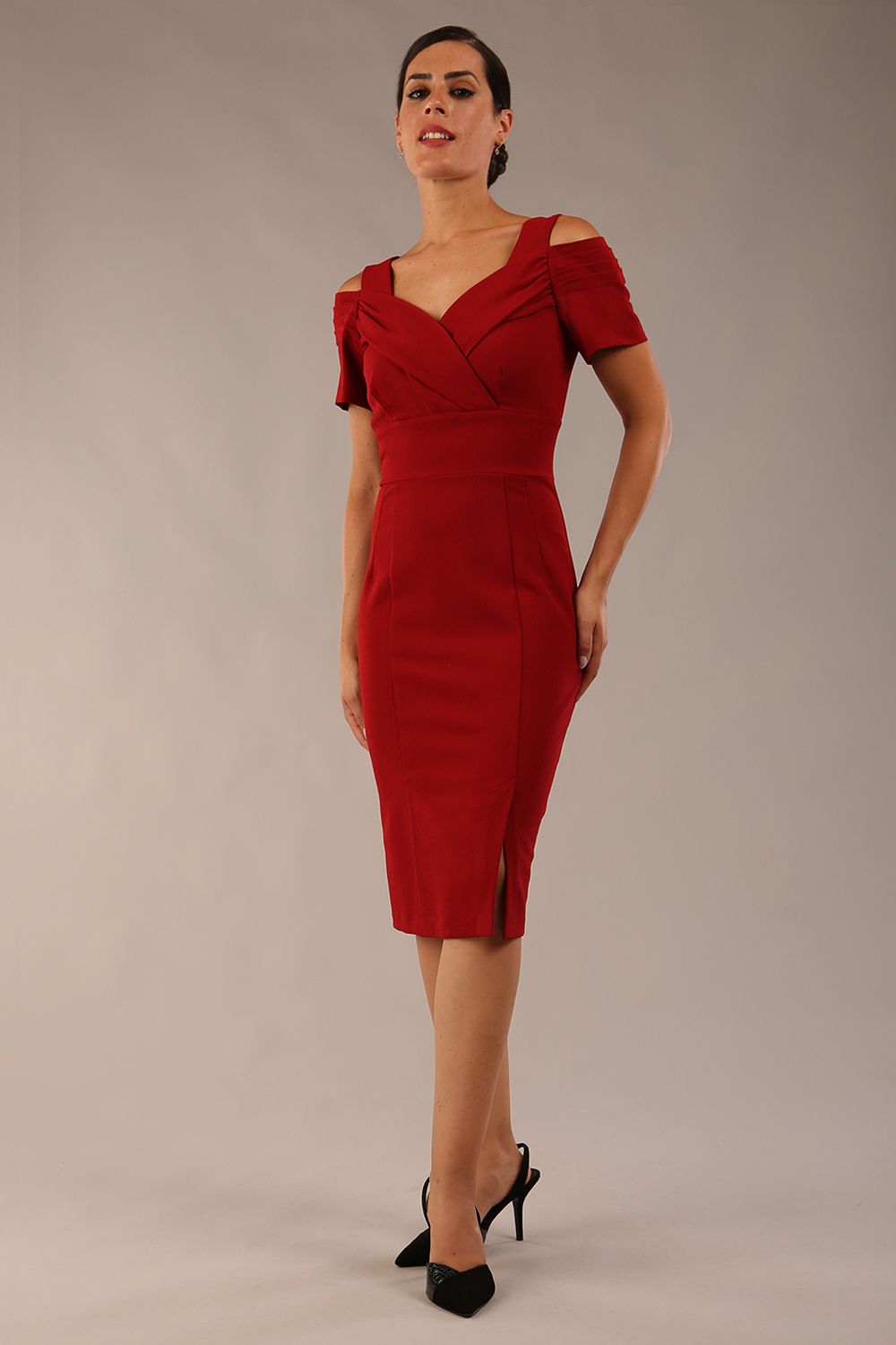 brunette model wearing diva catwalk amorette pencil skirt dress with a cold shoulder detaul and pleating across the bust and slit on a side of skirt in rosewood red colour front