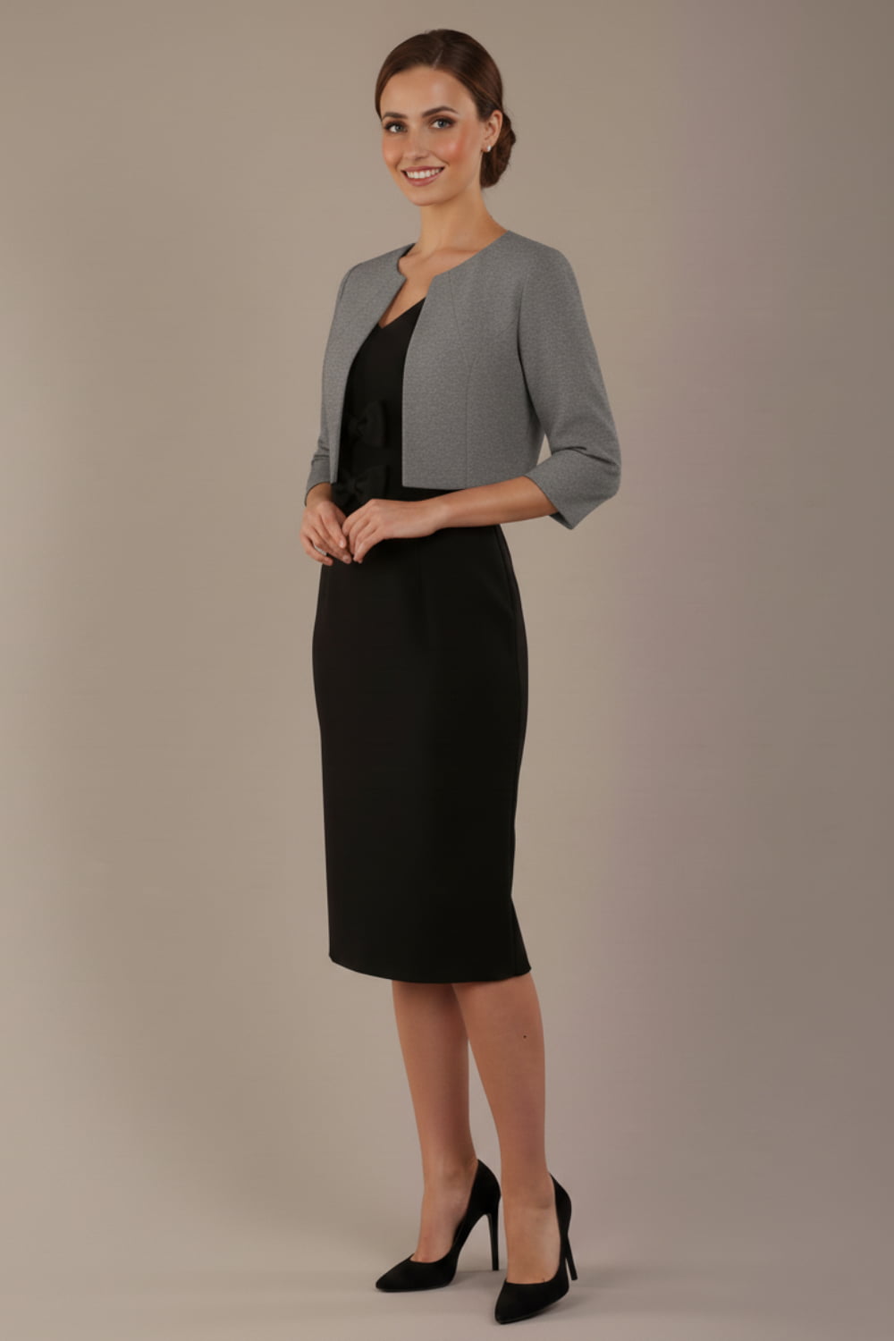 Woman wearing a black dress with a gray jacket on a beige background (Misty Grey)