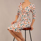 brunette model is wearing a diva catwalk Cynthia Floral Print Dress sleeved crossover v neckline knee length in Linear Tulip Print front image