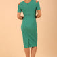 Model wearing the Diva Atlas Pencil dress with round neckline short sleeved dress with small cutouts on the shoulders in emerald green back