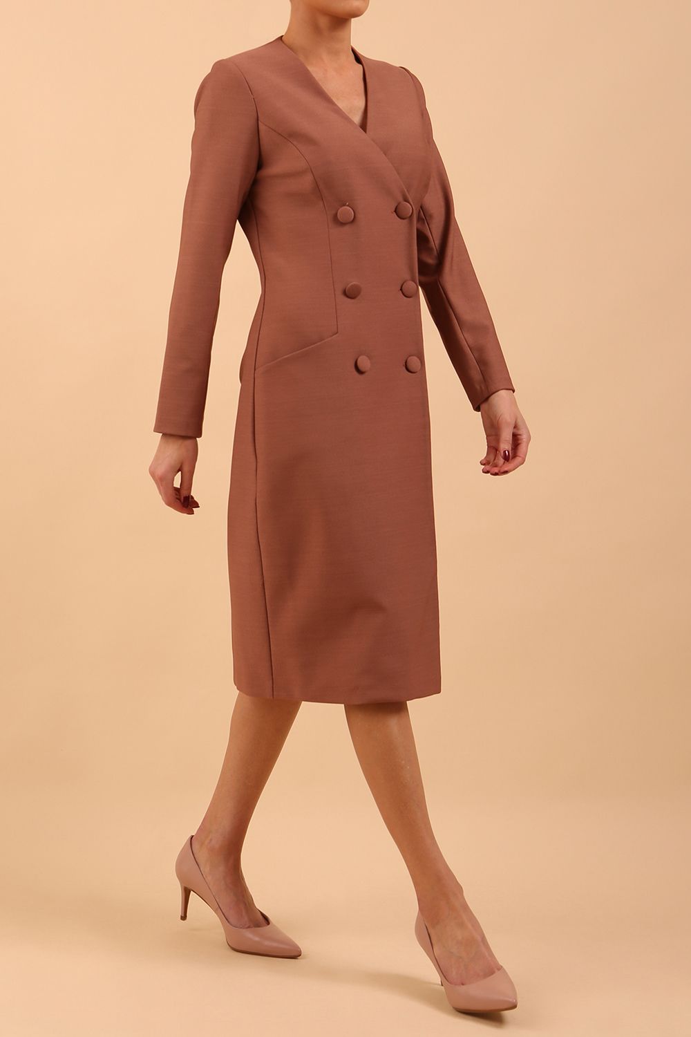 Brunette model wearing a diva catwalk Seed Silverstone Long Sleeve Coat Dress with 6 buttons across the front and pockets in colour Acorn Brown front side