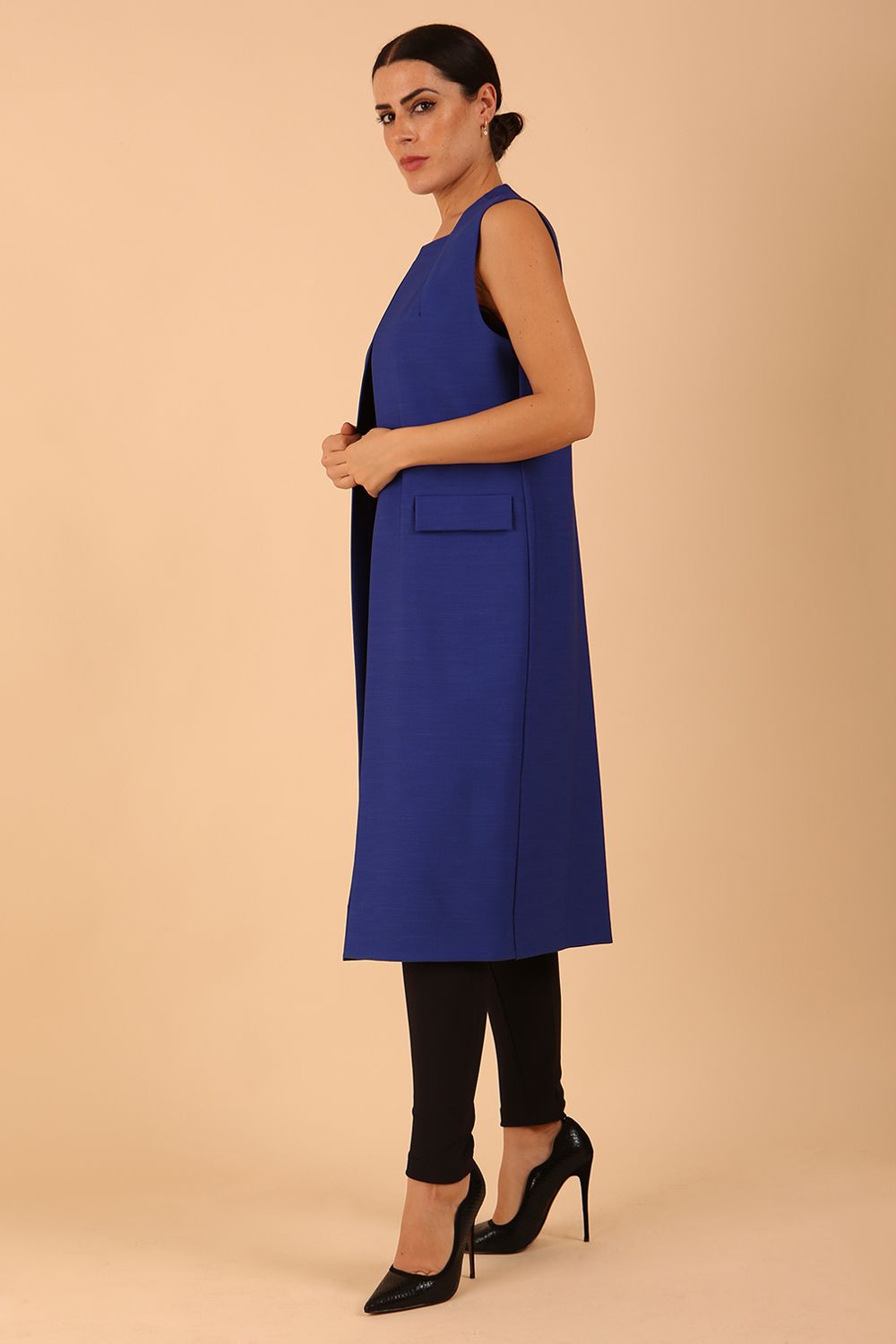 model wearing a divacatwalk Seed Harvard Sleeveless Coat midi length in Monaco Blue colour front side