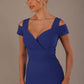 Woman wearing a riviera blue diva catwalk hayward pencil dress with short sleeves against a beige background close up