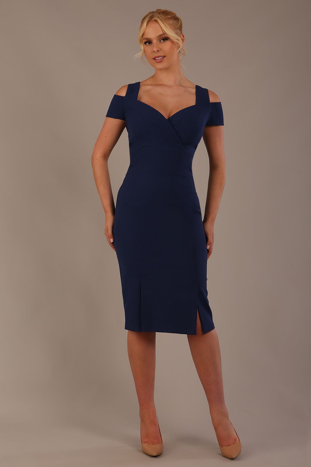 Woman wearing a navy blue diva catwalk hayward pencil dress with short sleeves against a beige background