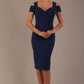 Woman wearing a navy blue diva catwalk hayward pencil dress with short sleeves against a beige background