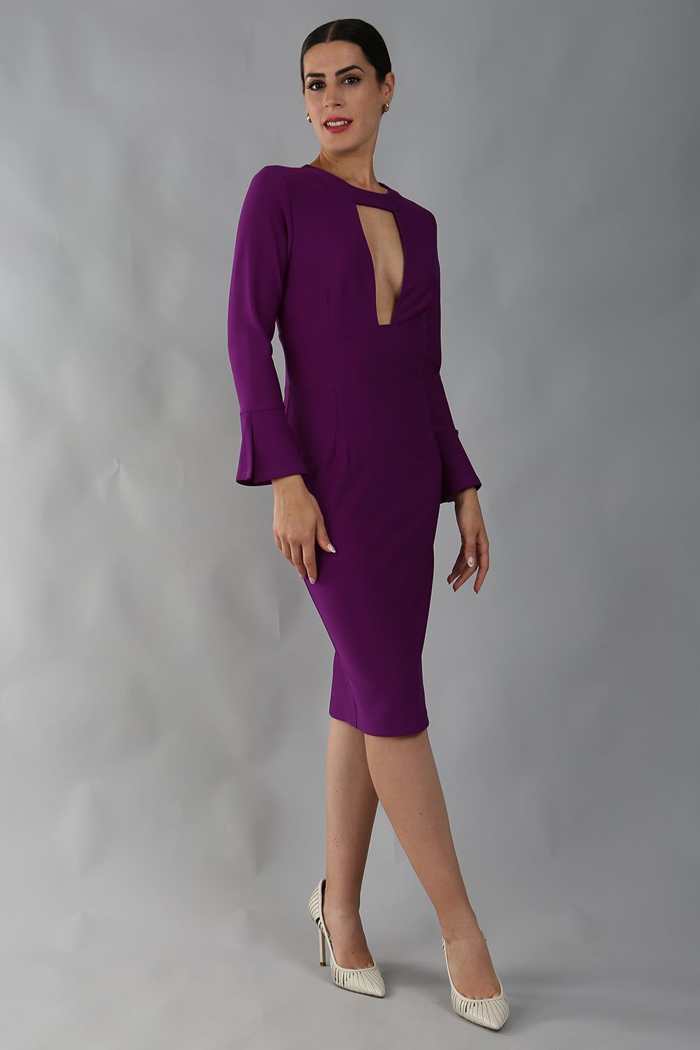 model is wearing diva catwalk fifi pencil skirt dress with three quarter flute sleeve and rounded neckline with a cut out at the front in magic purple 