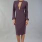 model is wearing diva catwalk fifi pencil skirt dress with three quarter flute sleeve and rounded neckline with a cut out at the front in mauve