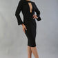 model is wearing diva catwalk fifi pencil skirt dress with three quarter flute sleeve and rounded neckline with a cut out at the front in black