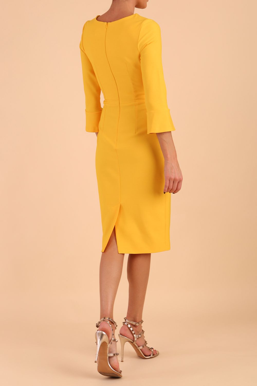 Model wearing diva catwalk Seed Orla Asymmetric Pencil Dress in Saffron Yellow back