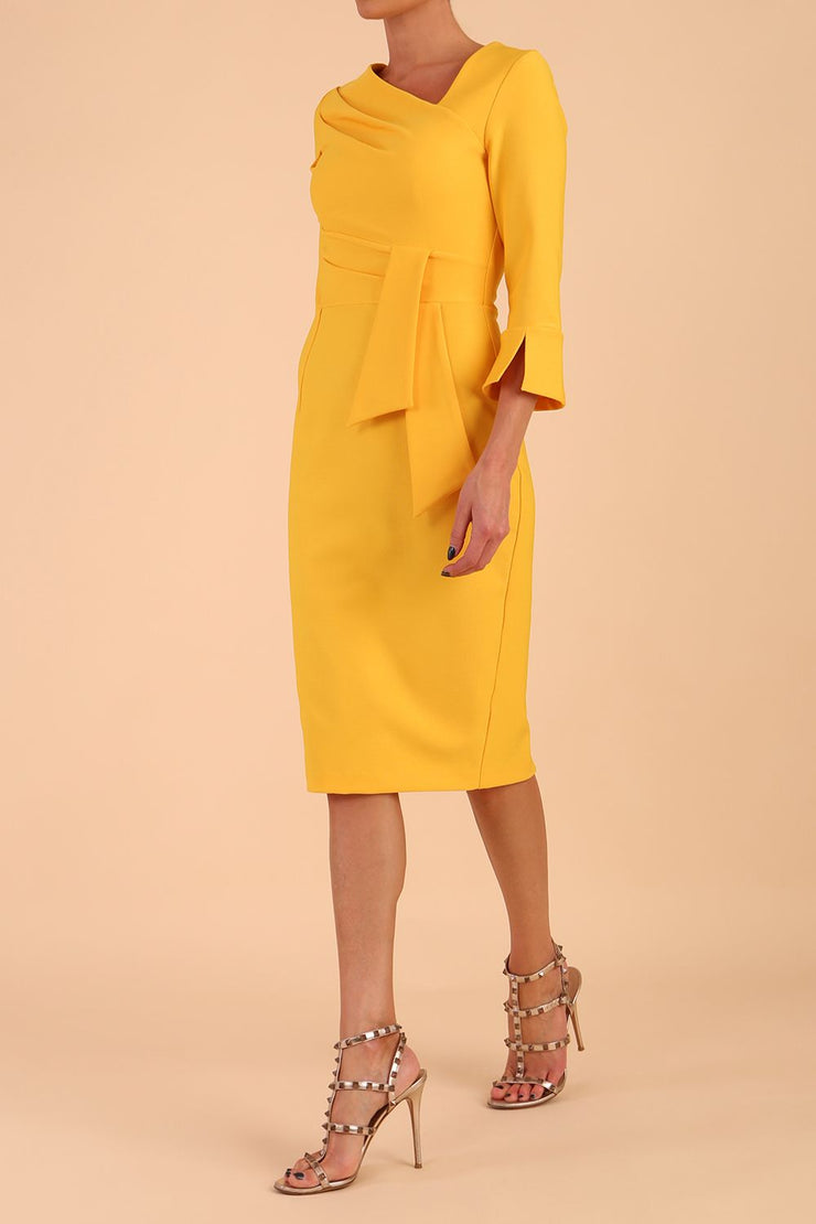 Model wearing diva catwalk Seed Orla Asymmetric Pencil Dress in Saffron Yellow front side