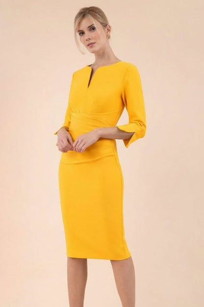 blonde model wearing seed tuscany pencil fitted dress in daffodil yellow colour with a split in the neckline and split detail on sleeves front (Daffodil Yellow)