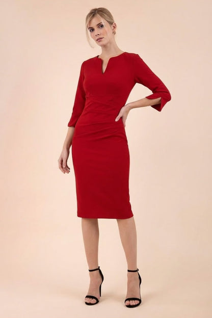 londe model wearing seed tuscany pencil fitted dress in cardinal red colour with a split in the neckline and split detail on sleeves front (Cardinal Red)