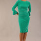 model is wearing a diva catwalk Winsford Velvet Dress with 3/4 peplum sleeve and rushing details knee length pencil dress in Golf green velvet colour