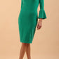 A brunette model is wearing a velvet long bell sleeve pencil dress maternity style in golf green colour front