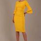 A woman wearing a sunshine yellow knee-length diva catwalk meridian pencil dress with a round neckline, double layered peplum three quarter length sleeves, and standing against a plain background.