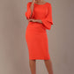 A woman wearing a hot coral knee-length diva catwalk meridian pencil dress with a round neckline, double layered peplum three quarter length sleeves, and standing against a plain background.