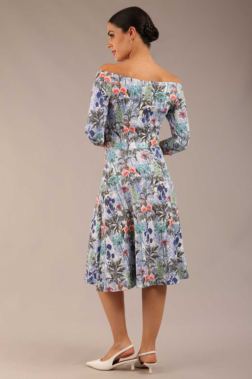 brunette model is wearing a diva catwalk islay a-line wing print dress off shoulder and knee length in water garden print back image