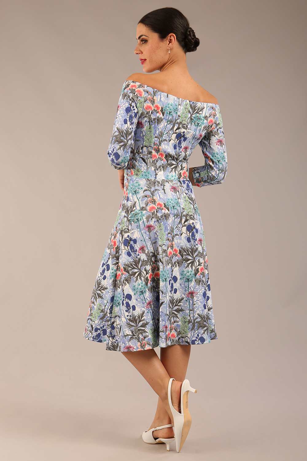 brunette model is wearing a diva catwalk islay a-line wing print dress off shoulder and knee length in water garden print back image