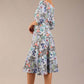 brunette model is wearing a diva catwalk islay a-line wing print dress off shoulder and knee length in water garden print front image