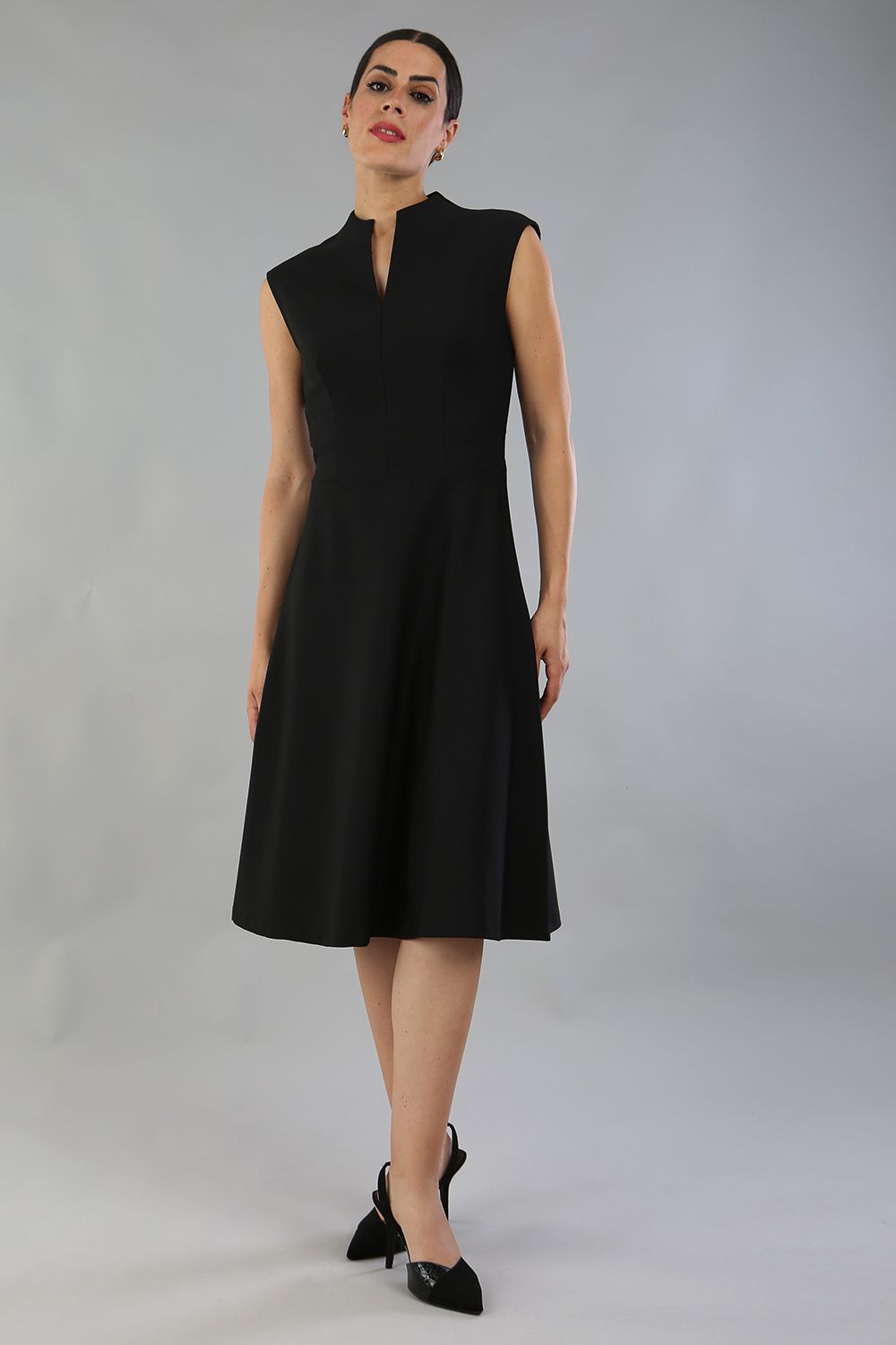 Brunette Model is wearing a sleeveless swing high neck dress with high neck in black by Diva Catwalk front