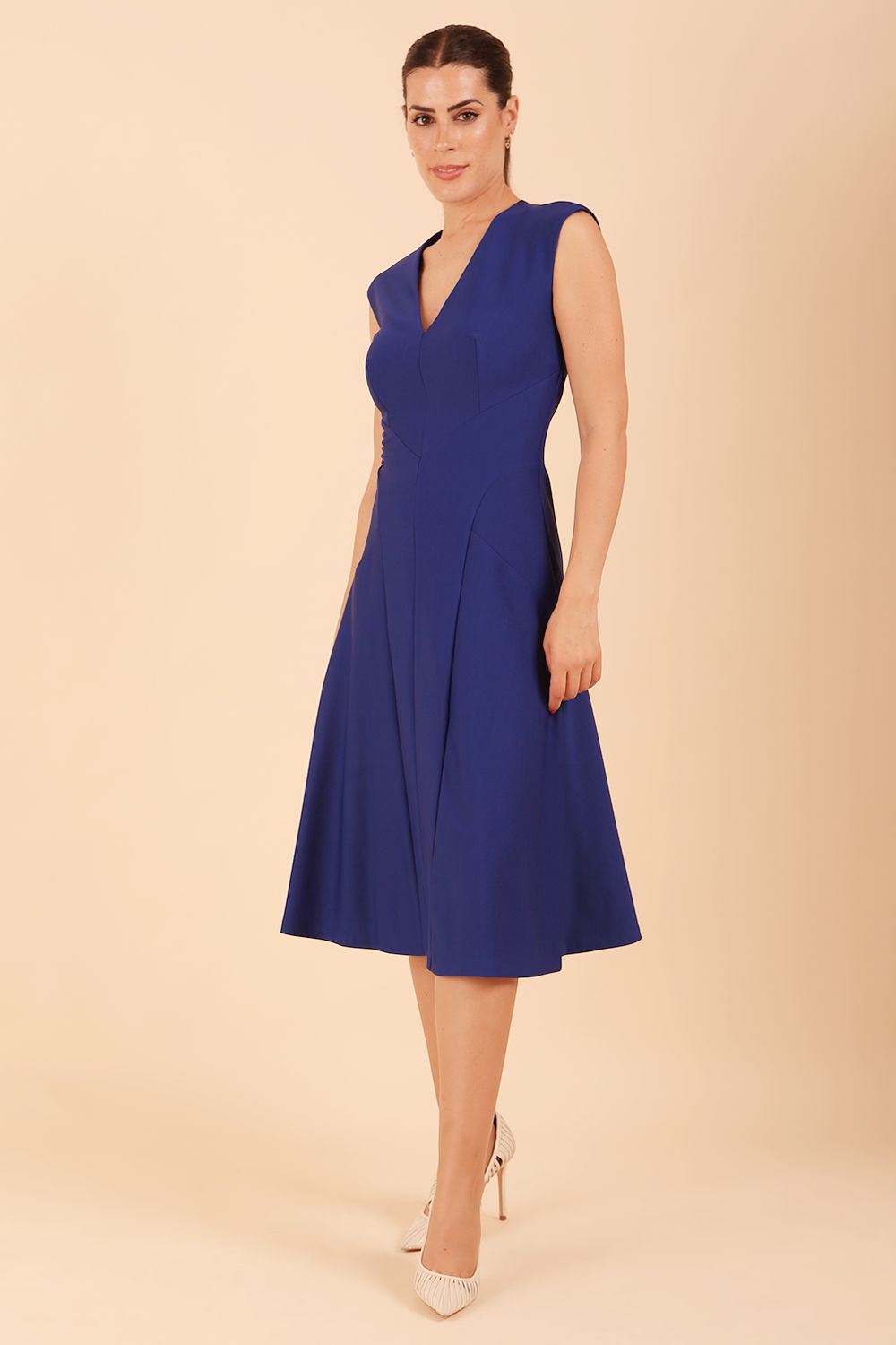 model wearing diva catwalk rochelle swing skirt a line dress without sleeves with a low v neck in cobalt front