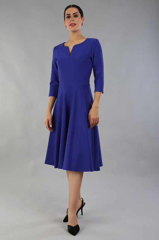 model wearing a diva catwalk Seed Corsham Swing Dress with 3/4 sleeve and below the knee length with v slit detail on the neckline in palace blue colour